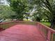 Large backyard featuring mature trees and a wooden deck for outdoor enjoyment at 10316 Woodhaven Cir, Indianapolis, IN 46229