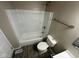 Compact bathroom featuring a shower-tub combo, toilet, vanity, and gray wood-style flooring at 10316 Woodhaven Cir, Indianapolis, IN 46229