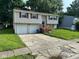 Split-level home featuring attached two-car garage and inviting front yard with mature landscaping at 10316 Woodhaven Cir, Indianapolis, IN 46229