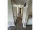Long hallway with wood-style flooring, white doors, and neutral paint, leading to various rooms at 10316 Woodhaven Cir, Indianapolis, IN 46229