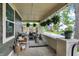 Relaxing covered front porch with stylish outdoor furniture and decorative hanging plants at 1046 N Hamilton Ave, Indianapolis, IN 46201