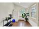 This sun room features hardwood floors, bright windows, a small refrigerator, and plants at 1046 N Hamilton Ave, Indianapolis, IN 46201