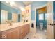 Stylish bathroom with double vanity, custom storage, and a separate toilet room enhanced by playful cloud and sun wall art at 10865 Fairwoods Dr, Fishers, IN 46037
