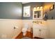 Charming powder room with a decorative mirror, beadboard paneling, and hardwood floors at 10865 Fairwoods Dr, Fishers, IN 46037