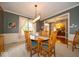 Formal dining room featuring a wood table, stylish chandelier, and large windows at 10865 Fairwoods Dr, Fishers, IN 46037