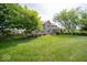 Expansive backyard showcases the home's exterior and lush landscaping at 10865 Fairwoods Dr, Fishers, IN 46037