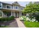 Covered front porch with white columns, a charming seating area, and lush landscaping at 10865 Fairwoods Dr, Fishers, IN 46037