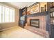 Living room with a brick fireplace and built-in shelving at 10865 Fairwoods Dr, Fishers, IN 46037