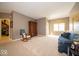 Comfortable living room featuring neutral colored walls, carpet, and large window for natural light, plus rocking chair and sofa at 10865 Fairwoods Dr, Fishers, IN 46037