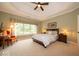 Comfortable main bedroom featuring a tray ceiling, large window, and neutral carpeting at 10865 Fairwoods Dr, Fishers, IN 46037