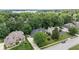 Aerial view of home surrounded by mature trees, professionally landscaped with lake in background at 11266 Old Stone Dr, Indianapolis, IN 46236