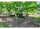 Backyard with a hot tub, grill, brick and wood exterior under a canopy of green foliage at 11266 Old Stone Dr, Indianapolis, IN 46236