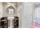 Charming powder room features a pedestal sink, decorative mirror, and a pink tile floor at 11266 Old Stone Dr, Indianapolis, IN 46236