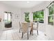 Bright breakfast nook with a glass table, upholstered chairs, and a view of the backyard through large windows at 11266 Old Stone Dr, Indianapolis, IN 46236