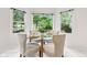 Charming breakfast nook boasts a glass table, elegant chairs, and a picturesque view of the green backyard at 11266 Old Stone Dr, Indianapolis, IN 46236