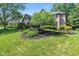 Two-story brick home featuring landscaped front yard with green grass and mature shade trees at 11266 Old Stone Dr, Indianapolis, IN 46236