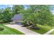 Side view of brick house with three-car garage, paved driveway and mature trees at 11266 Old Stone Dr, Indianapolis, IN 46236