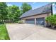 Brick house exterior featuring a two-car garage, a side-entry garage, and a spacious concrete driveway at 11266 Old Stone Dr, Indianapolis, IN 46236