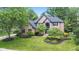 Brick two-story home featuring a manicured lawn, professional landscaping, and arched window at 11266 Old Stone Dr, Indianapolis, IN 46236
