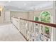 Hallway with white railing overlooking sitting area with many windows and light neutral colors at 11266 Old Stone Dr, Indianapolis, IN 46236
