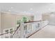 Hallway with white railing overlooking sitting area with many windows and light neutral colors at 11266 Old Stone Dr, Indianapolis, IN 46236