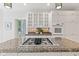 Modern kitchen showcasing a granite island cooktop, white cabinets, and stainless steel appliances at 11266 Old Stone Dr, Indianapolis, IN 46236