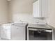 Close up of modern washer and dryer in laundry room featuring a sink, cabinetry, and neutral decor at 11266 Old Stone Dr, Indianapolis, IN 46236