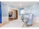 Bright office with blue walls, glass desk, stylish chair, and doorway view to the dining and stairs at 11266 Old Stone Dr, Indianapolis, IN 46236