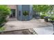 A concrete patio featuring a grill, bordered by lush greenery and part of the home's backyard setup at 11266 Old Stone Dr, Indianapolis, IN 46236
