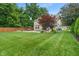 Expansive backyard featuring lush lawn, mature trees, and a charming patio with pergola at 11763 Igneous Dr, Fishers, IN 46038