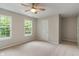 Sun-filled bedroom with neutral walls and carpet, showcasing bright windows and a ceiling fan at 11763 Igneous Dr, Fishers, IN 46038