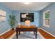 Stylish office with a dark wood desk, bright blue walls, and natural light from the window at 11763 Igneous Dr, Fishers, IN 46038