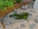 Backyard pond with a charming swing, lush greenery, decorative stone work, and waterfall at 11763 Igneous Dr, Fishers, IN 46038