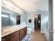 Large bathroom with double sinks, a large mirror, a closet, and wood-look floors at 13829 Black Canyon Ct, Fishers, IN 46038