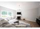 Bright living room featuring a gray sectional sofa, fireplace, and a large window at 13829 Black Canyon Ct, Fishers, IN 46038