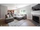 Bright living room featuring a gray sectional sofa, fireplace, and a large window at 13829 Black Canyon Ct, Fishers, IN 46038
