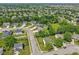 A serene neighborhood featuring tree-lined streets, manicured lawns, and a tranquil pond at 14729 Erica Ln, Carmel, IN 46033