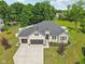 Aerial view of a house with a large driveway, well-manicured lawn, and mature trees in a suburban setting at 14729 Erica Ln, Carmel, IN 46033