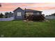 Home exterior with a spacious wooden deck featuring steps down to the lush green lawn at 14729 Erica Ln, Carmel, IN 46033