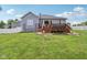 Exterior view of home with a spacious wooden deck featuring steps down to the lush green lawn at 14729 Erica Ln, Carmel, IN 46033