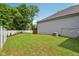 Spacious backyard featuring a manicured lawn, white fence, mature trees, and a partial view of the deck at 14729 Erica Ln, Carmel, IN 46033