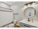 Modern bathroom with a white shower curtain, gray vanity, round mirror, and updated fixtures at 14729 Erica Ln, Carmel, IN 46033