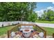 Cozy seating area on wooden deck with modern outdoor furniture and fire pit, overlooking a large backyard at 14729 Erica Ln, Carmel, IN 46033
