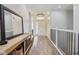 Inviting foyer featuring wood floors, modern light fixtures, arched doorway, and a staircase with black wrought iron at 14729 Erica Ln, Carmel, IN 46033