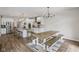 Bright, open kitchen featuring a large island, modern appliances, and a dining area with a rustic table and bench seating at 14729 Erica Ln, Carmel, IN 46033