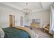 Bright main bedroom features a chandelier, wood floors, and a bench in front of the bed at 14729 Erica Ln, Carmel, IN 46033