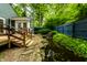The backyard features a waterfall, pond, beautiful landscaping, a wooden deck and a blue fence at 1515 Randall Rd, Indianapolis, IN 46240