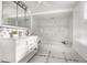 Bright bathroom featuring marble-patterned tile, a vanity sink, and bathtub with coordinating tile surround at 1515 Randall Rd, Indianapolis, IN 46240