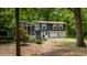 Exterior view of a two-story home with a screened-in porch, nestled among lush trees at 1515 Randall Rd, Indianapolis, IN 46240