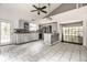 Open kitchen with gray cabinets, stainless steel appliances and bright natural lighting flowing to living area at 1515 Randall Rd, Indianapolis, IN 46240